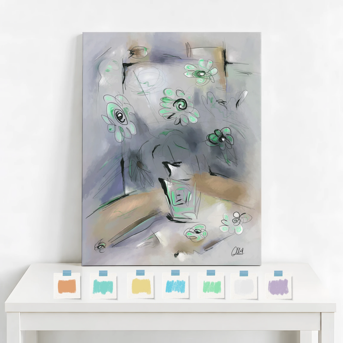 An abstract canvas painting with soft gray, beige, and mint green tones, displayed leaning against a white wall above a white table. Along the bottom edge of the image, a row of small color chips in orange, blue, yellow, green, white, and purple is shown.
