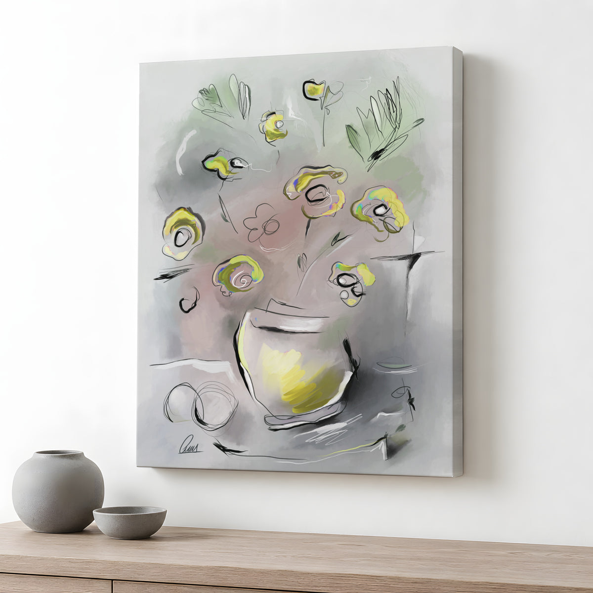 An abstract floral canvas print with yellow and green flowers in a gray and white pot, displayed on a light wood console table against a white wall, with two gray ceramic vases in the foreground.